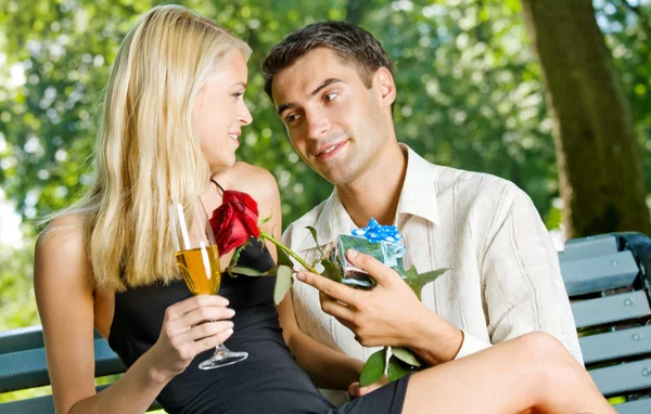 年轻快乐夫妇与香槟、 礼物和户外的玫瑰， — 图库照片