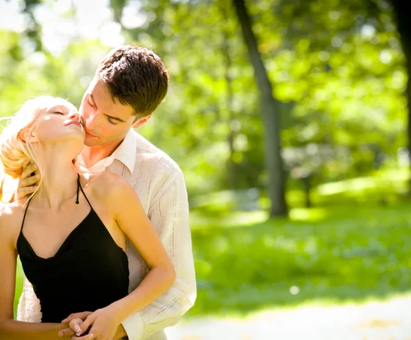 Portrait de jeune couple heureux et attrayant embrassant, en plein air — Photo