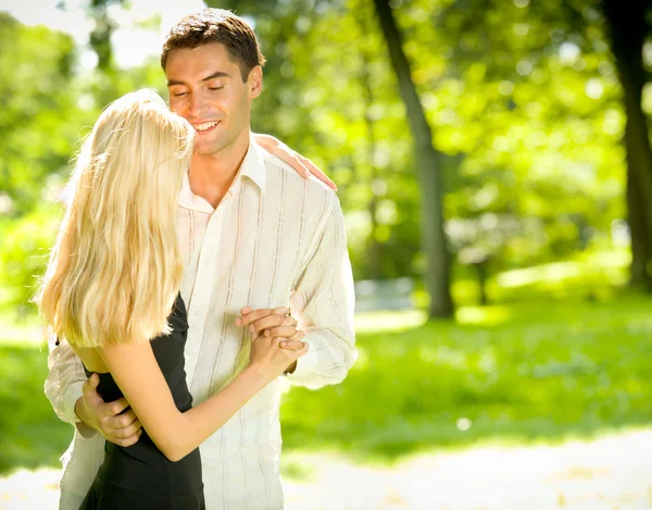 Portrait de jeune couple heureux et attrayant embrassant, en plein air — Photo