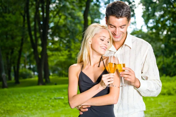 Jeune couple heureux célébrant avec du champagne, en plein air — Photo