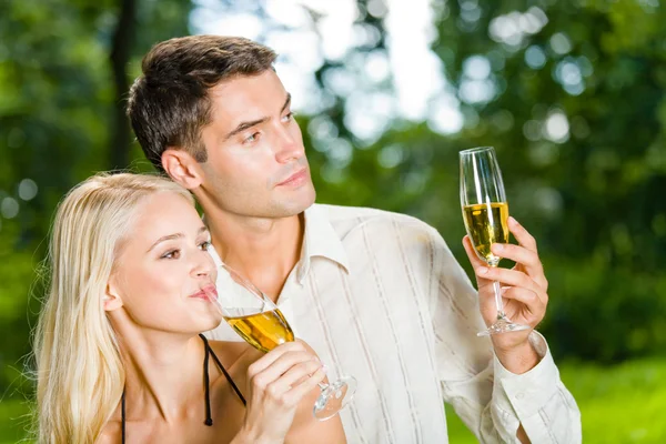 Jeune couple heureux célébrant avec du champagne en plein air — Photo