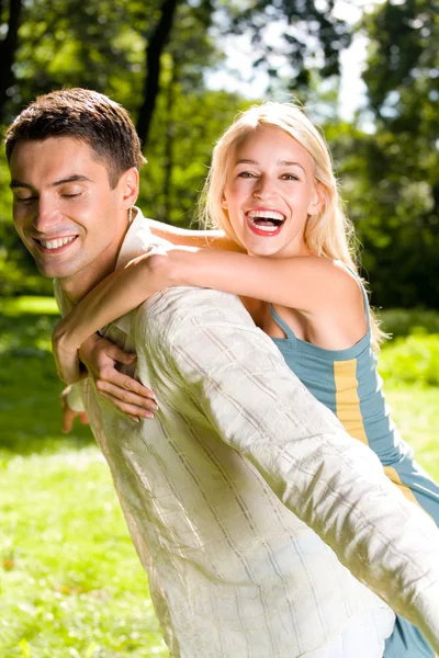 Young happy attractive embracing couple, outdoors — Stock Photo, Image