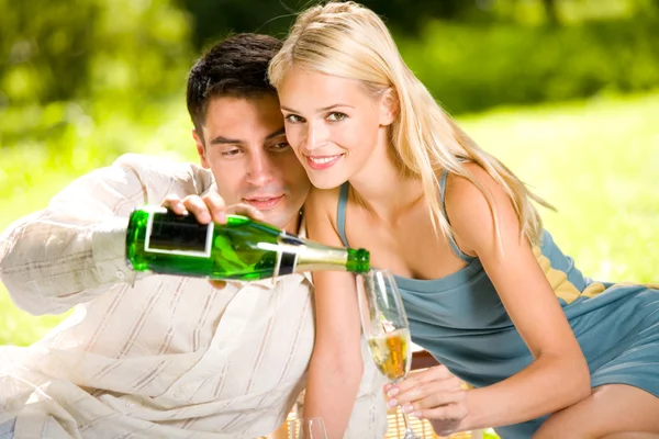 Mladý pár, slaví se šampaňským dohromady, venku — Stock fotografie