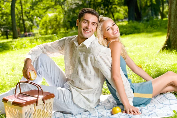 Jonge gelukkige paar met appels op picnic, buitenshuis — Stockfoto