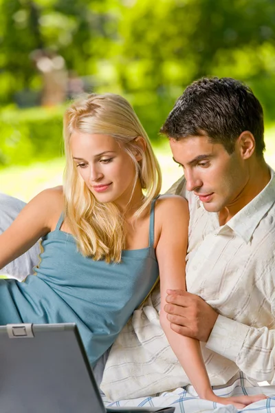 Młody szczęśliwy uśmiechający się para z laptopa na pikniku — Zdjęcie stockowe
