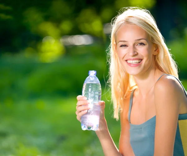 Молодая женщина с бутылкой воды на открытом воздухе — стоковое фото