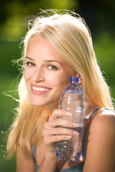 Retrato de bela mulher sorridente com garrafa de água, outdoo — Fotografia de Stock