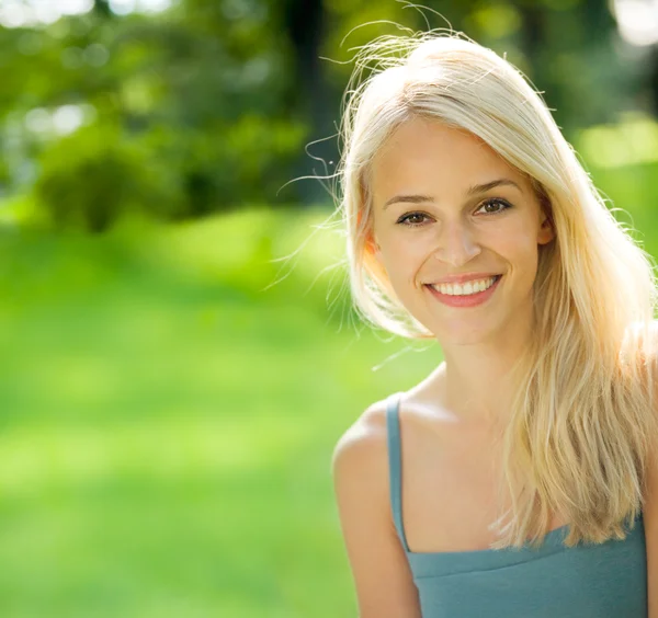 Портрет молодой привлекательной улыбающейся блондинки, на открытом воздухе — стоковое фото