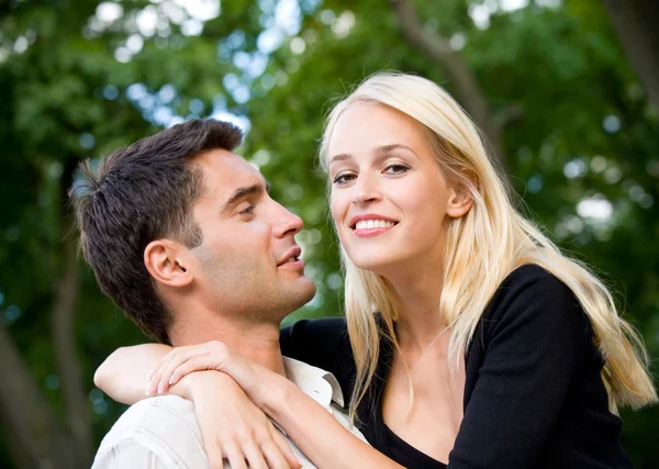 Jovens felizes abraçando casal andando juntos ao ar livre — Fotografia de Stock