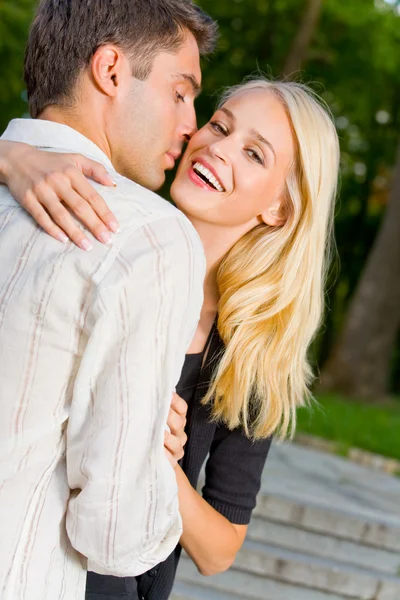 Jovem feliz atraente abraçando casal, ao ar livre — Fotografia de Stock