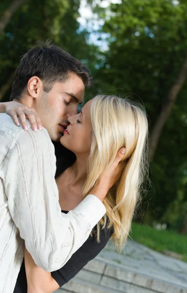 Молодая счастливая влюбленная пара целуется на открытом воздухе — стоковое фото