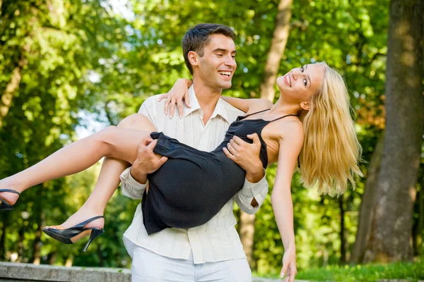 Junges glückliches attraktives Paar, das zusammen im Freien spaziert — Stockfoto