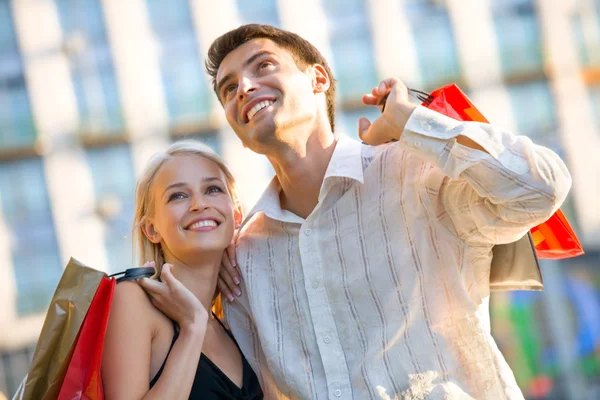 Młody atrakcyjny szczęśliwa para z torby na zakupy na zewnątrz — Zdjęcie stockowe