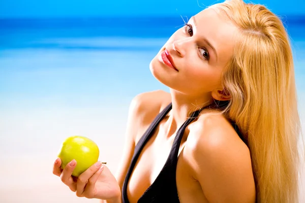 Jovem sexual bonita sorrindo mulher loira com maçã em biquíni — Fotografia de Stock