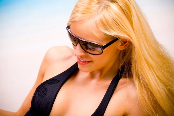 Jovem mulher bonita em óculos de sol e biquíni na praia do mar — Fotografia de Stock