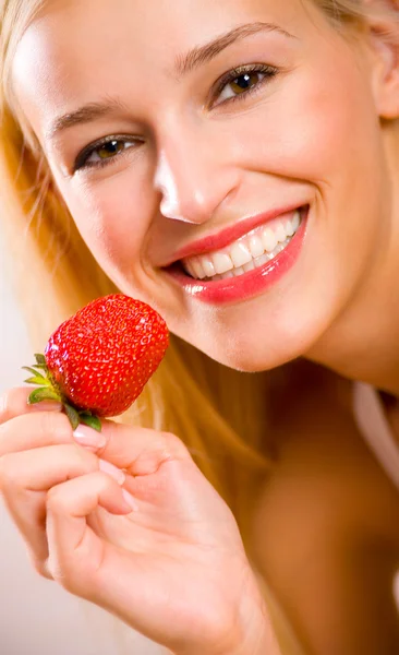 Unga vackra glada leende kvinna med jordgubbe på stranden — Stockfoto