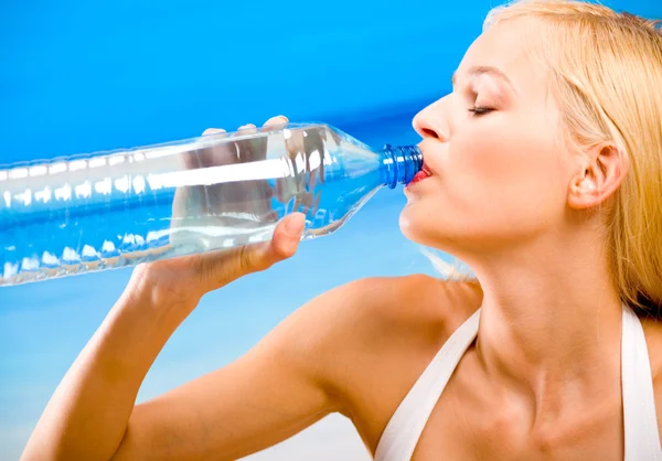 Junge schöne glücklich lächelnde blonde Frau mit Flasche Wasser i — Stockfoto
