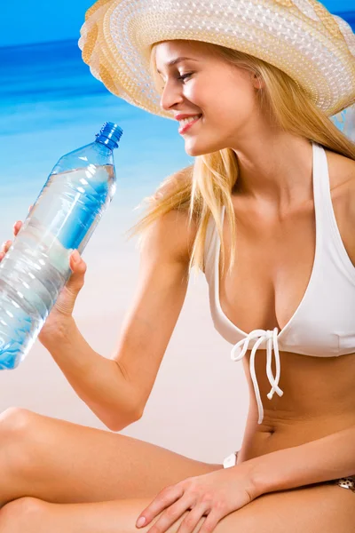 Retrato de mujer hermosa con botella de agua en la playa — Foto de Stock