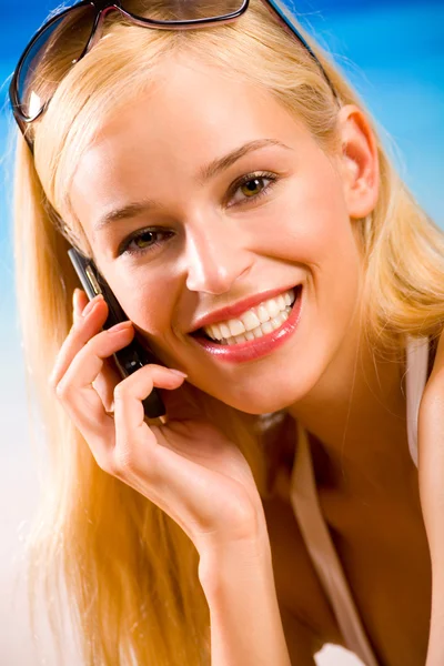 Junge schöne sexy gebräunte blonde Frau mit Handy im Bikini — Stockfoto