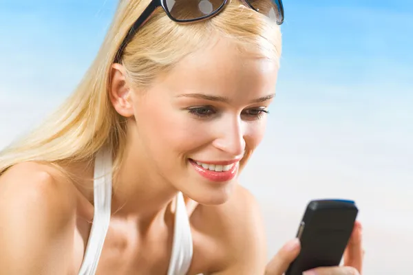 Felice sorridente bella donna con cellulare sulla spiaggia — Foto Stock
