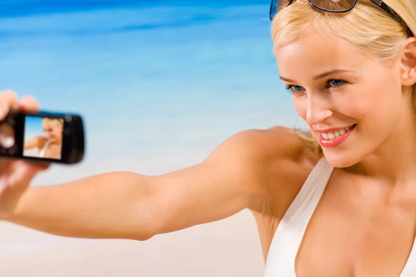 Stock image Woman taking photograph by cellphone or digital camera on beach