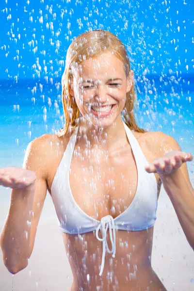 Młoda kobieta szczęśliwa biorąc prysznic lub w deszczu na plaży — Zdjęcie stockowe