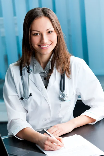 Счастливый врач или медсестра с ручкой и буфетом обмена в офисе — стоковое фото