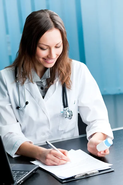 Glad kvinnliga läkare med p-piller och Urklipp i office — Stockfoto