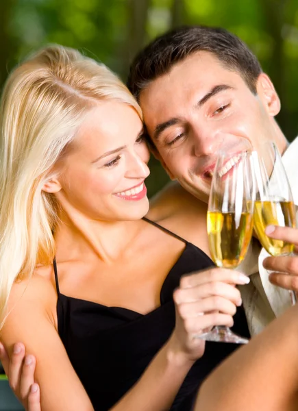 Young couple celebrating with champagne together, outdoors Royalty Free Stock Images