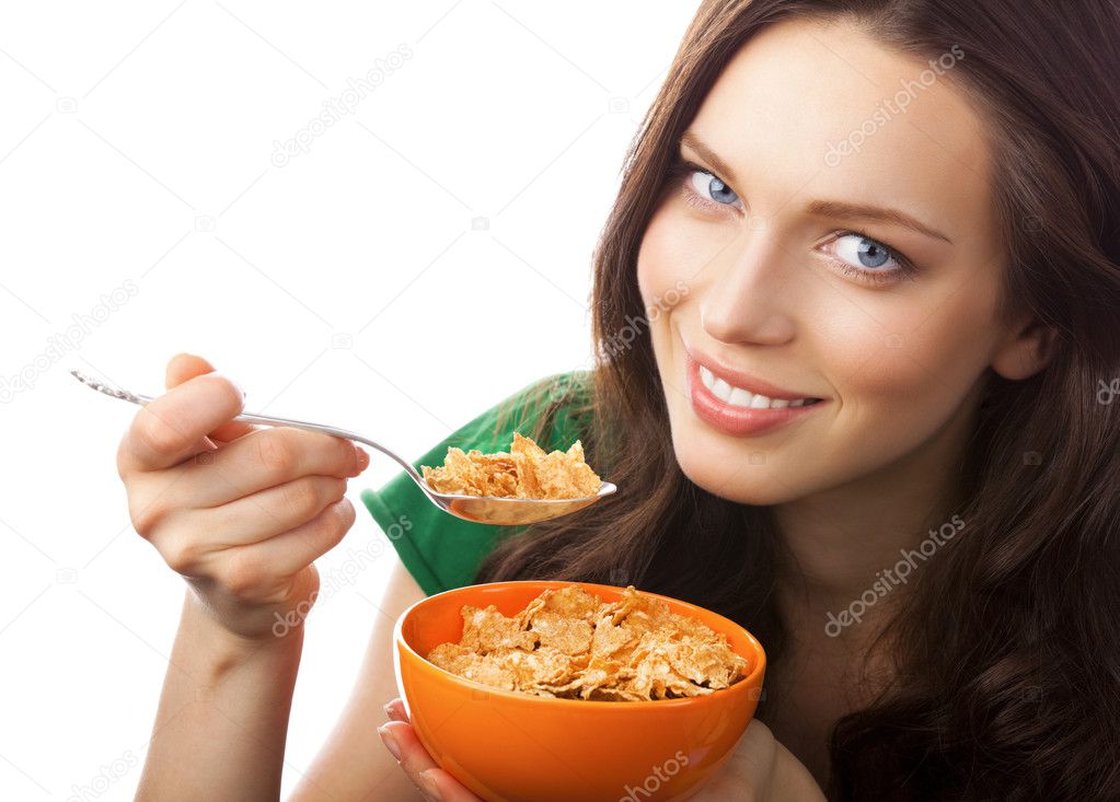Portrait of young smiling woman eating muesli or cornflakes, iso
