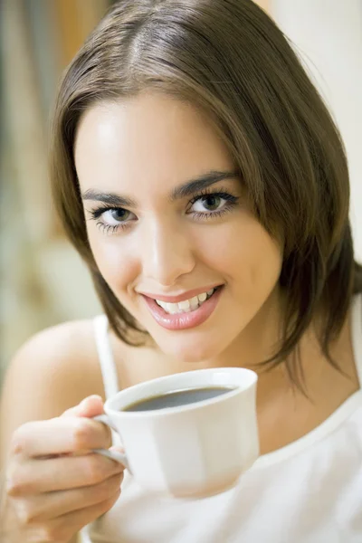 마시는 커피, 집에서 젊은 행복 한 웃는 여자 — 스톡 사진