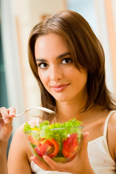 Молодая счастливая улыбающаяся женщина с салатом дома — стоковое фото