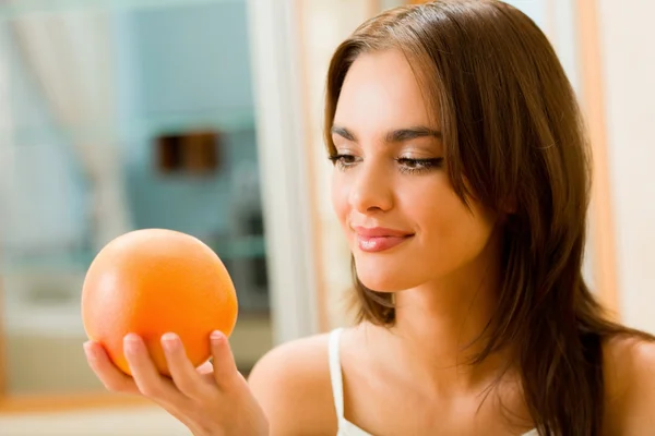 Ung kvinna med grapefrukt hemma — Stockfoto