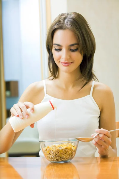 Joven mujer feliz con muselina de cereales y leche en casa —  Fotos de Stock