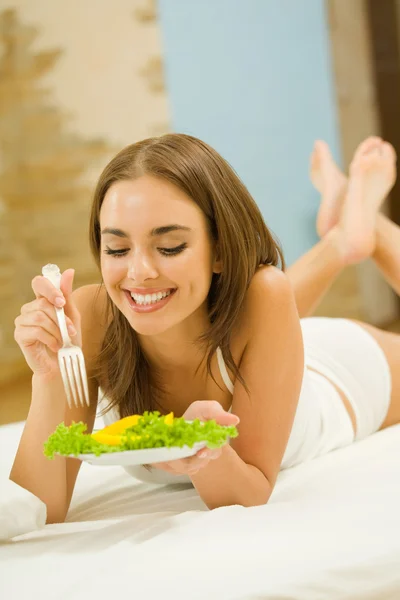 Portrait of young happy woman eating salad at home — Stock Photo, Image