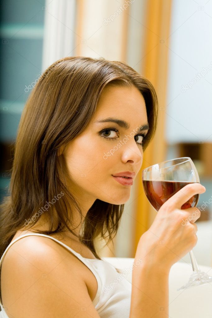Young woman with glass of red wine, indoors