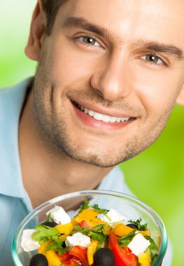 mutlu genç gülümseyen adam portresi ile tabak salata, açık