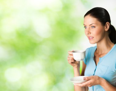 Young happy smiling woman drinking coffee, outdoors clipart