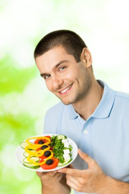 mutlu genç gülümseyen adam portresi ile tabak salata, açık