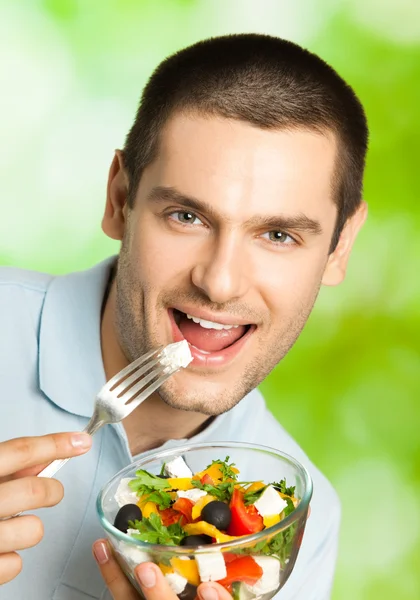 Stock image Portrait of young happy man eating salad, outdoors