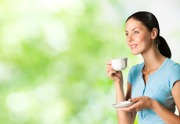 Jeune femme souriante heureuse buvant du café, en plein air — Photo