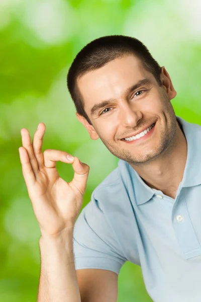 Portrait of young happy smiling attractive man with okay gesture — Stock Photo, Image