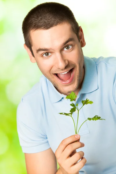 Jonge gelukkig lachende man met potherbs, buiten — Stockfoto