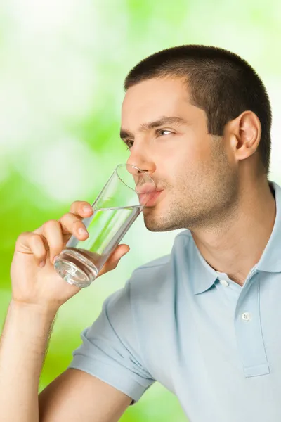 Молодой человек пьет воду на открытом воздухе — стоковое фото