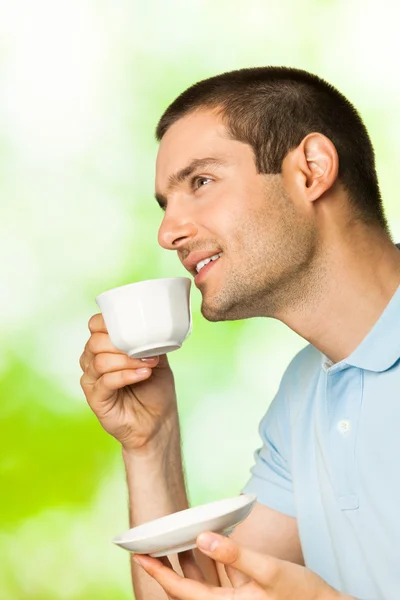 Stock image Young happy smiling man drinking coffee, outdoors