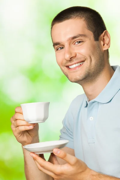 Portret van jonge gelukkig lachende man drinken koffie, buitenshuis — Stockfoto