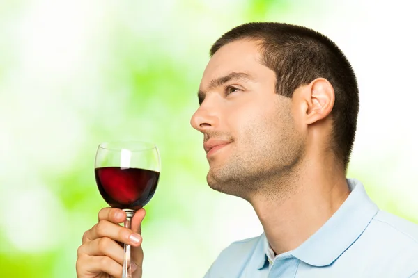 Młody człowiek z kieliszek czerwonego wina, na zewnątrz — Zdjęcie stockowe