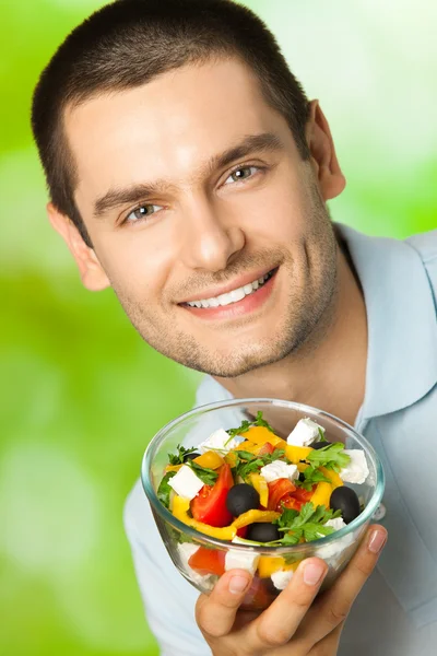 Mutlu genç gülümseyen adam portresi ile tabak salata, açık — Stok fotoğraf