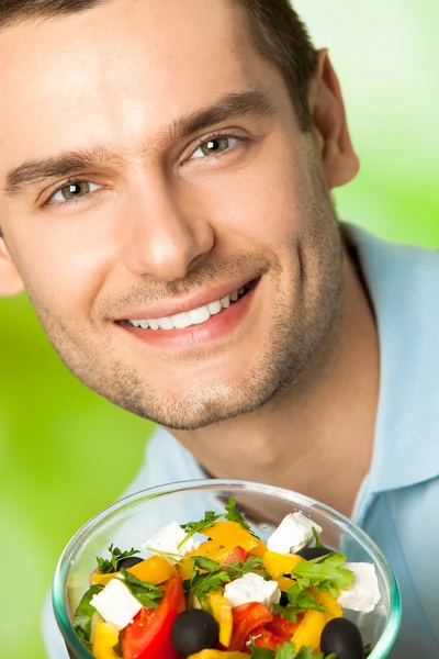 Portrait of young happy smiling man with plate of salad, outdoor — Stock Photo, Image