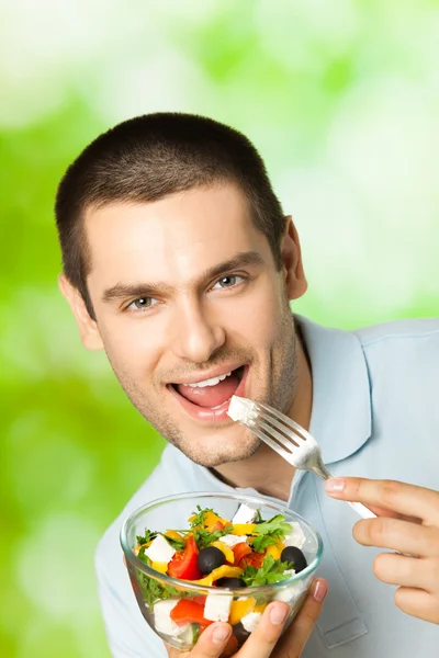 Mutlu delikanlı yeme salata, açık havada portresi — Stok fotoğraf